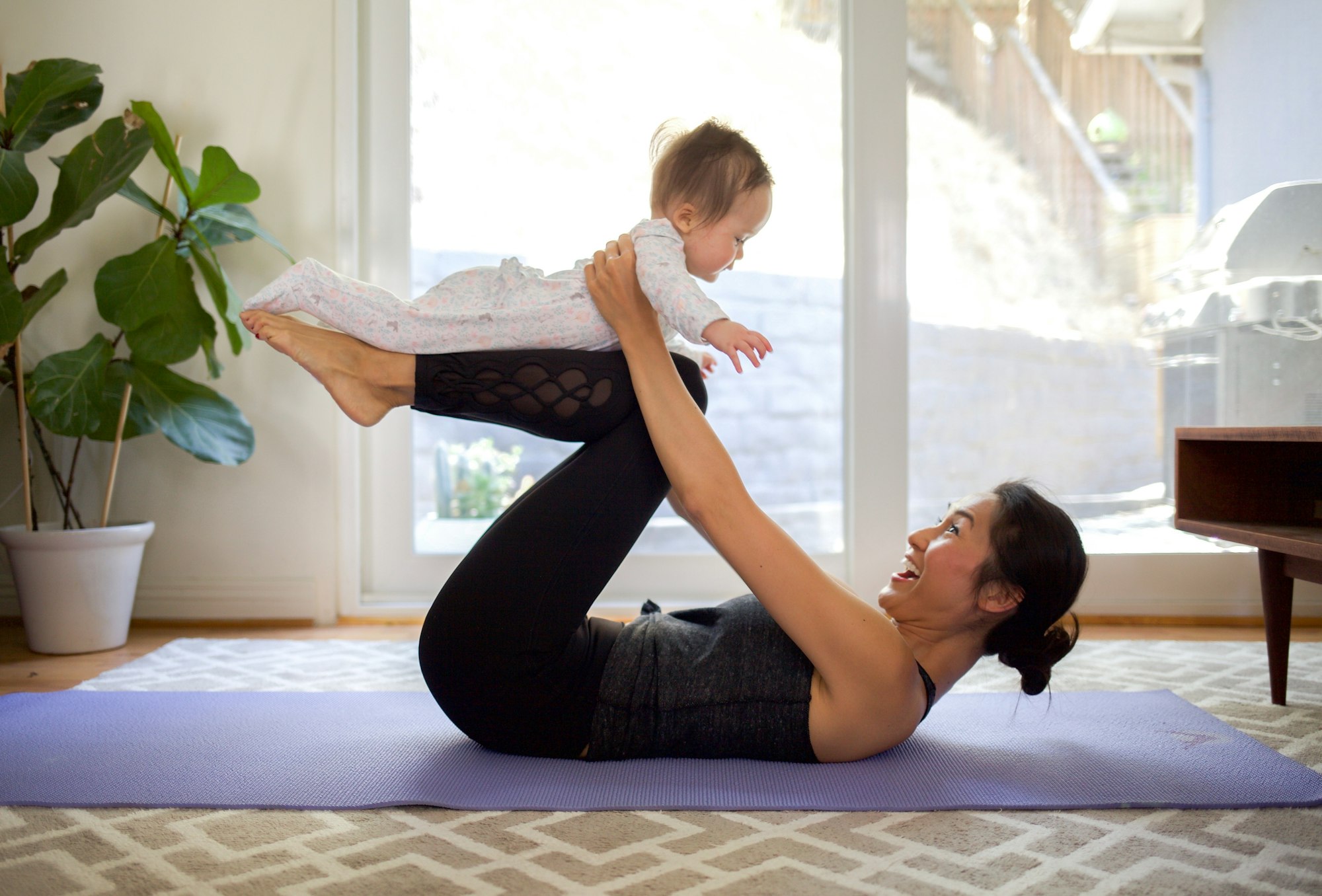 Mother and baby doing yoga at home